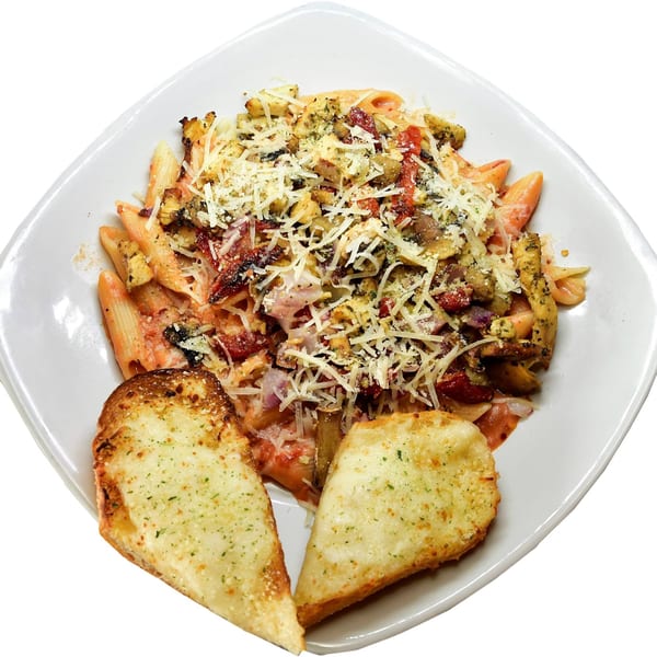 Penne pasta with chicken, sun-dried tomatoes, and cheese, served with two pieces of garlic bread.