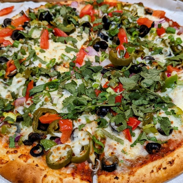 Fun Pizza Kitchen's pizza with fresh cilantro, tomatoes, olives, jalapenos, and onions.
